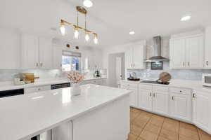 Kitchen with white cabinets, light stone countertops, tasteful backsplash, and light tile patterned floors