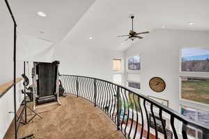Hallway with carpet floors, lofted ceiling, and recessed lighting