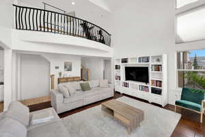 Living room featuring dark wood-style floors, a high ceiling, and recessed lighting