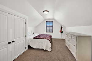 Bedroom featuring dark carpet and a closet