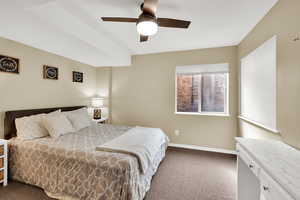 Bedroom with dark colored carpet and ceiling fan