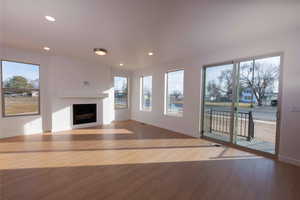 Unfurnished living room featuring a fireplace, plenty of natural light, recessed lighting, and light wood-style floors