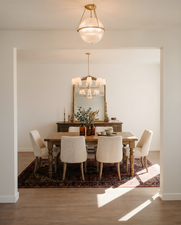 Formal dining area featuring a gold-finish chandelier and a decorative area rug