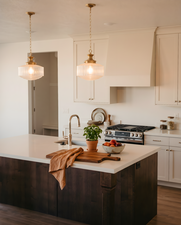 Kitchen featuring an island with a light-colored countertop, dark wood-finish cabinetry, and a gooseneck faucet