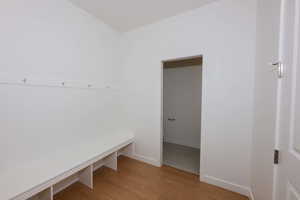 Mudroom featuring light wood finished floors and baseboards