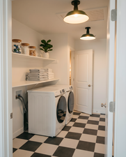 Dedicated laundry area featuring a black and white checkered floor, built-in shelving, and contemporary ceiling light fixtures