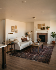 Living space featuring a brick fireplace with a white mantel, recessed lighting, and wood-finish flooring