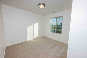 Spare room with light carpet and baseboards