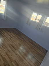 Empty room with dark wood-style floors and baseboards