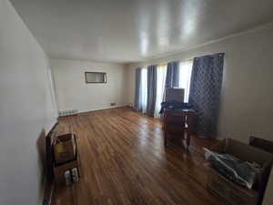 Living area featuring dark wood-style flooring and baseboards