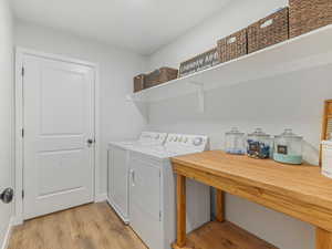 Laundry area featuring light wood-type flooring and separate washer and dryer