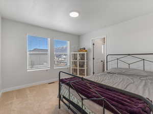 Bedroom featuring baseboards and light colored carpet