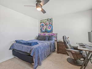 Bedroom with a desk, light carpet, and ceiling fan