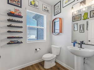 Bathroom featuring toilet and dark wood-type flooring