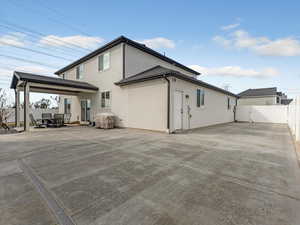 Rear view of property featuring a fenced backyard, a gate, and stucco siding
