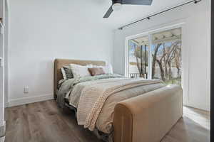 Bedroom with access to exterior, wood finished floors, and a ceiling fan