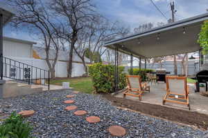 Fenced backyard featuring a patio and a grill