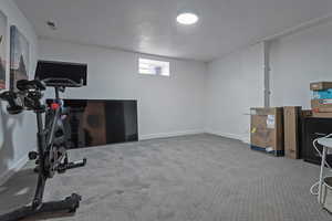 Workout room featuring light carpet and baseboards