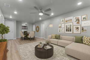 Living area with a ceiling fan, recessed lighting, and light wood finished floors