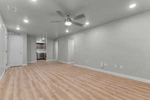 living room featuring ceiling fan, recessed lighting, light wood-style flooring, and a textured ceiling