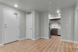 living room with recessed lighting, light wood-type flooring, and a textured ceiling