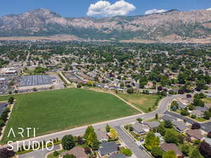 Aerial view of property and surrounding area featuring a mountain backdrop and nearby suburban area