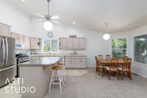 Kitchen with stainless steel appliances, a center island, a kitchen bar, lofted ceiling, and light countertops