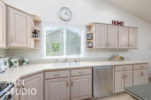 Kitchen with open shelves, stainless steel appliances, light wood finish cabinets, lofted ceiling, and light countertops