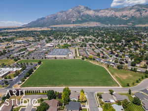 Aerial view of property and surrounding area featuring a mountain backdrop and nearby suburban area