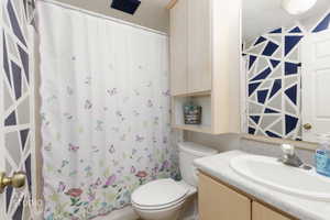 Bathroom featuring vanity and shower / bath combo with shower curtain