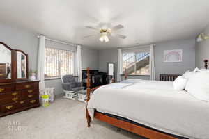 Bedroom featuring carpet floors, multiple windows, and a ceiling fan