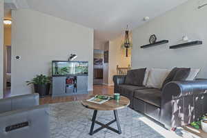 Living area with light wood-type flooring and vaulted ceiling