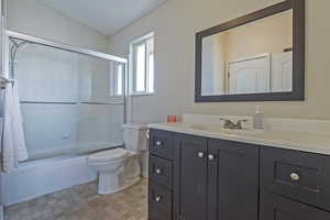 Full bath with vanity and bath / shower combo with glass door