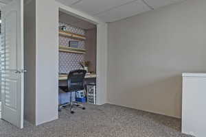 Office area featuring built in study area, light carpet, and a drop ceiling