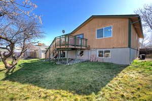 Back of house featuring a deck and a shed
