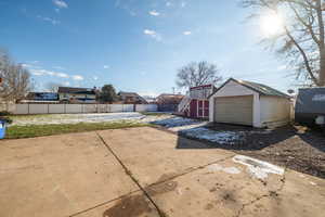 Fenced yard with a storage unit and a patio
