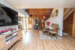 Dining room with log walls, a wood stove, and light wood finished floors