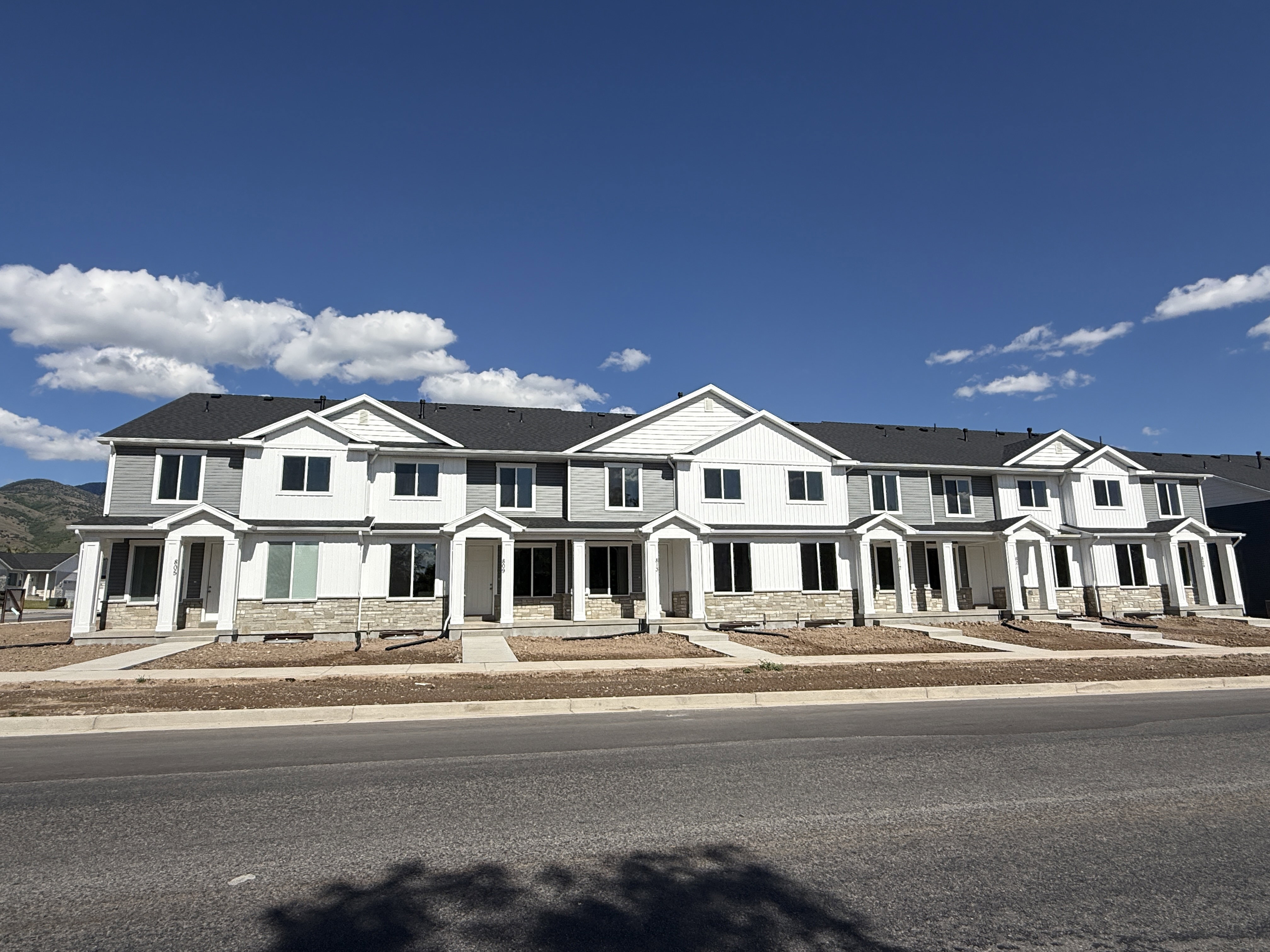 Modern townhome community featuring a combination of horizontal siding and stone veneer
