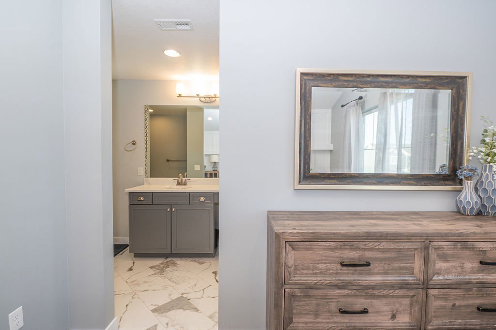 Bathroom featuring light marble finish flooring, vanity, and recessed lighting