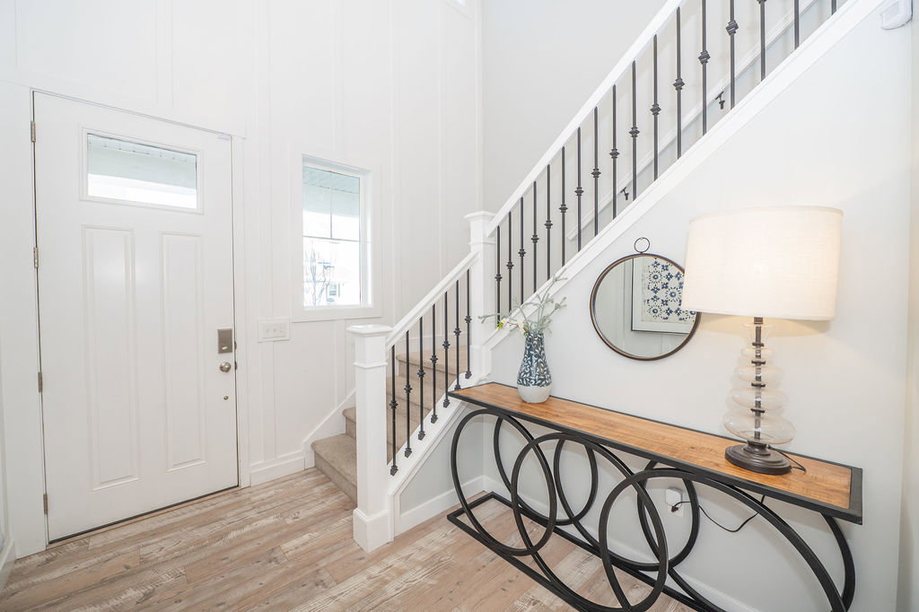 Foyer entrance with stairs and light wood-style floors