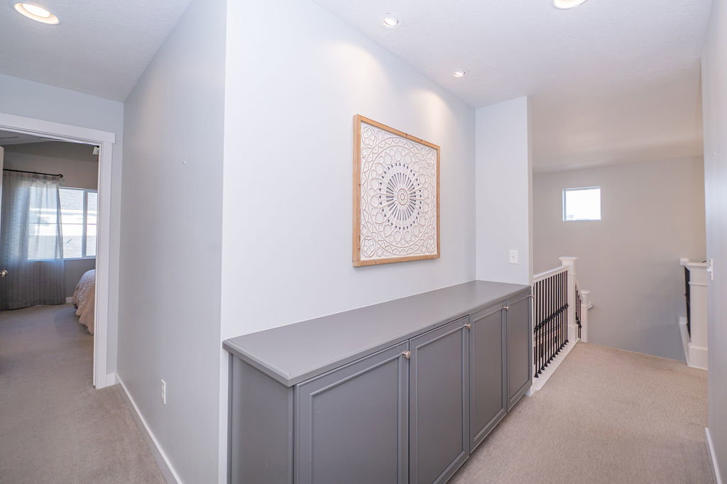 Corridor featuring light colored carpet, an upstairs landing, and recessed lighting