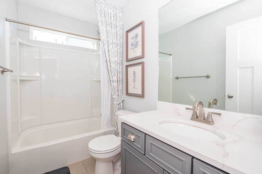 Bathroom with vanity, shower / bath combo, and light tile patterned floors