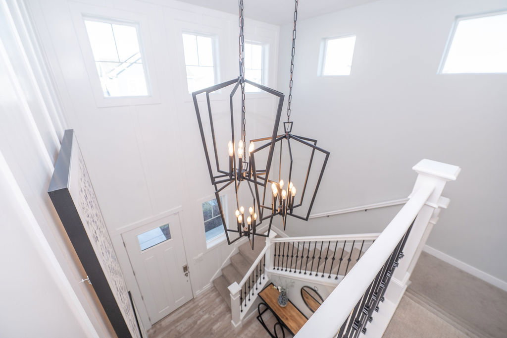 Staircase featuring suspended lighting, a high ceiling, and wood finished floors