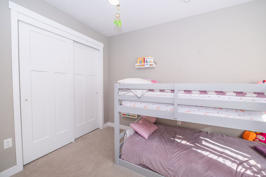 Bedroom with light carpet and a closet