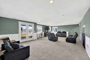 Living area with carpet, a wainscoted wall, a decorative wall, and recessed lighting