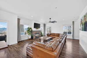 Living room with ceiling fan, dark wood-style floors, a fireplace, and recessed lighting