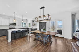 Dining space featuring dark wood-style flooring and a chandelier