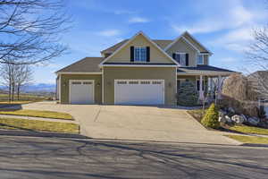 Craftsman-style home with driveway, board and batten siding, a porch, roof with shingles, and an attached garage