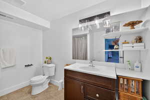 basement Full bath with vanity, light tile patterned floors, and a shower with curtain