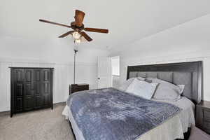 Master bedroom with wainscoting and ceiling fan